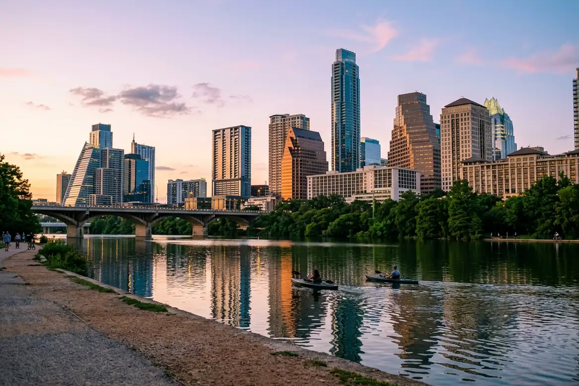 The Austin skyline at sunset across Lady Bird Lake, with the Congress Avenue Bridge.