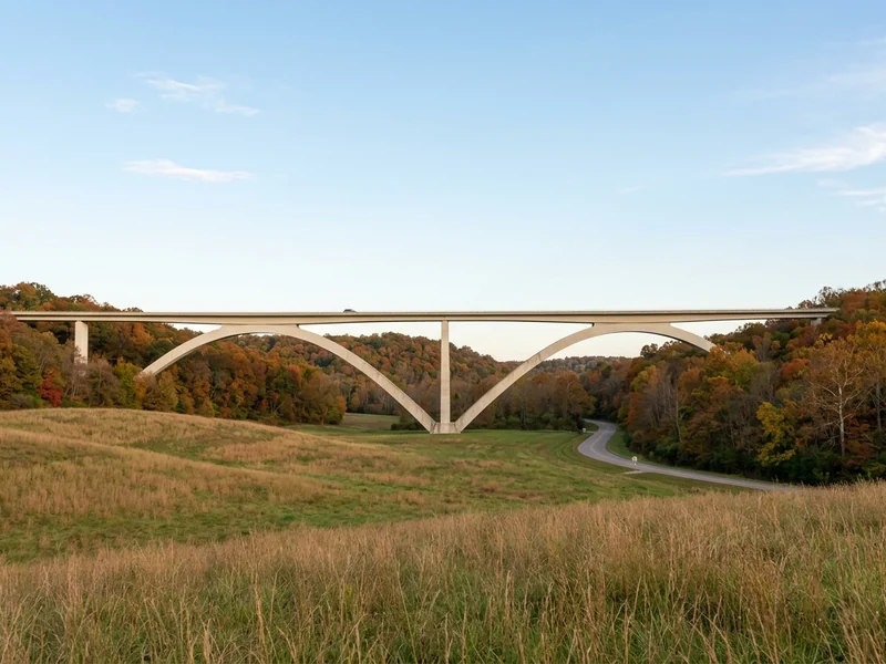 The Double Arch Bridge on the Natchez Trace Parkway in Tennessee, among autumn trees.