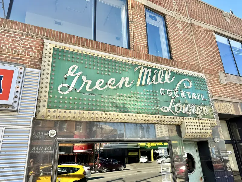 The green neon sign of the Green Mill jazz club on Broadway in Uptown, Chicago.