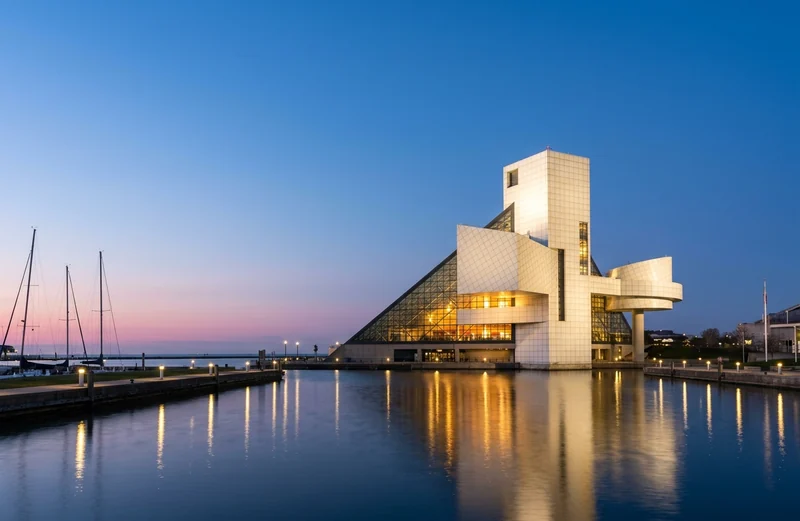 The Rock and Roll Hall of Fame on the Cleveland lakefront at dusk, lit from inside.